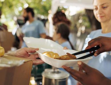 volunteers handing out meal boxes at a community thanksgiving event