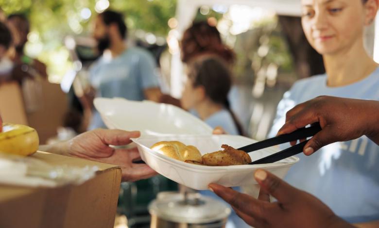 volunteers handing out meal boxes at a community thanksgiving event