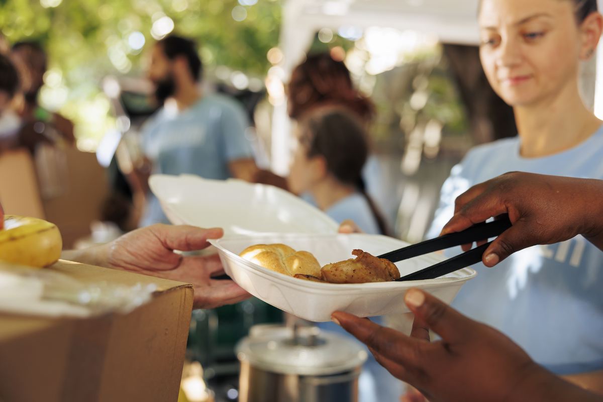 volunteers handing out meal boxes at a community thanksgiving event