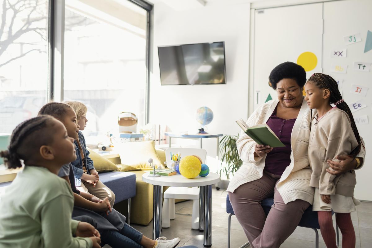 teacher reading a gratitude book at a thanksgiving class party